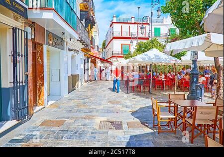 SANLUCAR, SPAIN - SEPTEMBER 22, 2019: The hundreds of tables and sunshades of cozy outdoor cafes and restaurants, located in Plaza del Cabildo square, Stock Photo