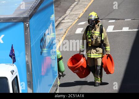 NSW Fire Brigade bring a special red container is brought to the scene to put the material into. Stock Photo