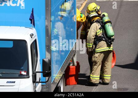 NSW Fire Brigade bring a special red container is brought to the scene to put the material into. Stock Photo