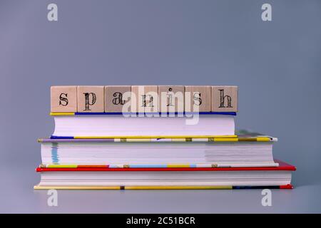 spanish language course and learning concept. stack of books with wooden blocks Stock Photo
