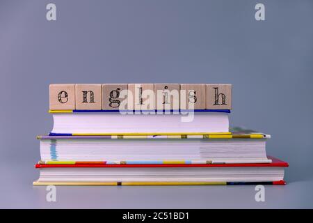 english language course and learning concept. stack of books with wooden blocks Stock Photo