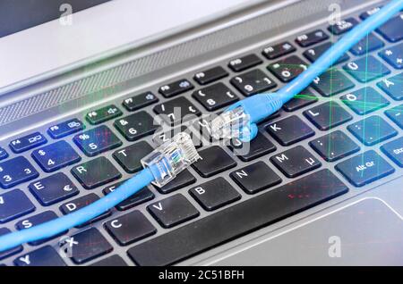 Two cables on computer keyboard symbolizing connection to cyberspace Stock Photo