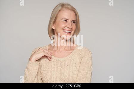 Close up portrait of beautiful older woman smiling. Isolated on grey Stock Photo
