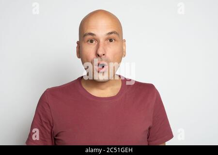 Shocked caucasian guy. Funny bald man isolated on grey background Stock Photo