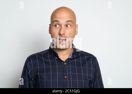 Surprised bald man is looking aside. Isolated on grey Stock Photo