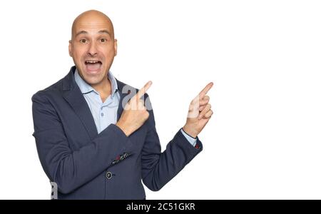 Surprised funny bald guy is pointing fingers aside. Isolated on grey background Stock Photo