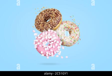 mix of multicolored sweet donuts with sprinkles on blue background Stock Photo