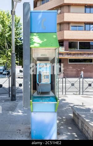 Jaen, Spain - June 18, 2020:  Public telephone kiosk along a town centre street. One of old and useless public phones that remains in public ways in S Stock Photo