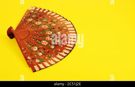 Stylish Classic Spanish Hand Fan on Bright Yellow Background. . Stock Photo