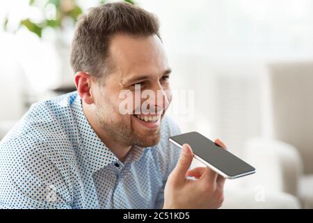Adult man using voice assistant on smartphone Stock Photo