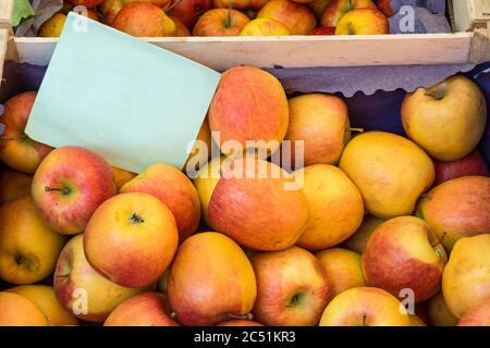 Fresh organic apples at the farmers market with blank cardboard sign Stock Photo