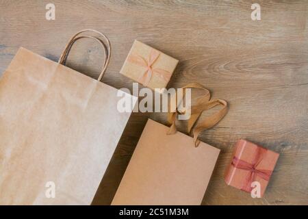 Craft paper bags and cardboard blank boxes presented on rustic wooden background. Unlabeled cardboard packages boxes and bags on wood table. Top view Stock Photo