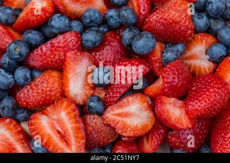 A full frame photograph looking down on a bowl of strawberries and blueberries Stock Photo