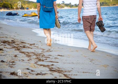 couple walking along the shore of a warm tropical sea Stock Photo