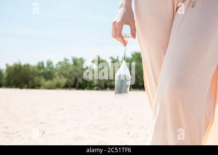 Taking champagne glasses. Seasonal feast at beach resort. Close up woman celebrating, resting, having fun in sunny summer day. Walking and taking the glass down. Festive time, wellness, holiday, party. Stock Photo