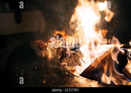 Steaks are grilled in the flames of fire. Stock Photo