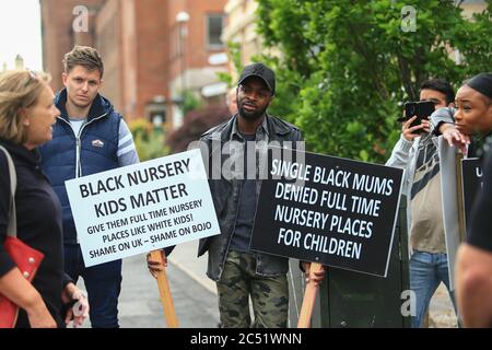 Dudley, West Midlands, UK. 30th June, 2020. As the Prime Minister Boris Johnson gave a speech in Dudley, a handful of protesters outside the college he was speaking in held up placards demanding full time nursery places for black children. Credit: Peter Lopeman/Alamy Live News Stock Photo