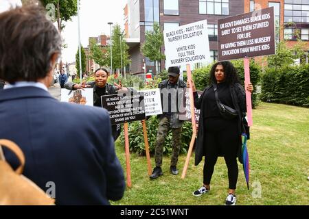 Dudley, West Midlands, UK. 30th June, 2020. As the Prime Minister Boris Johnson gave a speech in Dudley, a handful of protesters outside the college he was speaking in held up placards demanding full time nursery places for black children. Credit: Peter Lopeman/Alamy Live News Stock Photo