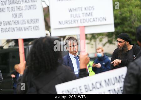 Dudley, West Midlands, UK. 30th June, 2020. As the Prime Minister Boris Johnson gave a speech in Dudley, a handful of protesters outside the college he was speaking in held up placards demanding full time nursery places for black children. Credit: Peter Lopeman/Alamy Live News Stock Photo