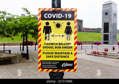 Caerphilly, Wales, UK.  30 June 2020. Coronavirus Covid-19 social distancing information notice on a lamp post in Caerphilly town centre. Credit: Tracey Paddison/Alamy Live News Stock Photo