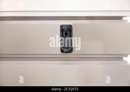 intercom with a doorbell and video link, closeup of a security device on a wall with copy space on outdoors exterior nobody. Stock Photo