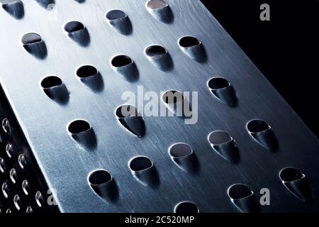 Metal chrome grater on black background. Macro close up view. Stock Photo