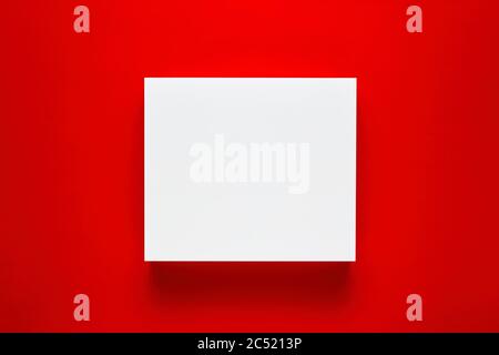 White blank square shape or frame on red background. Mockup for product or text display. Stock Photo