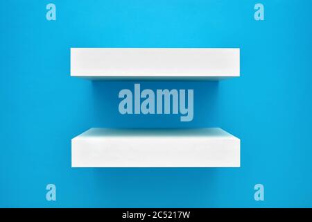 Empty white shelves on blue background. Blank product shelves panel for product display Stock Photo