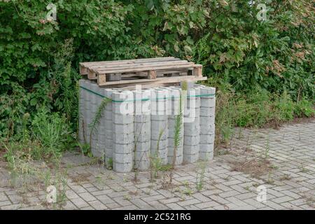 stack of hexagonal concrete bricks with wooden pallets on them Stock Photo