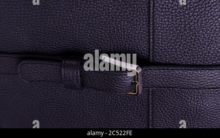Silver metal clasp on a black leather belt against Genuine leather texture background. Stock Photo