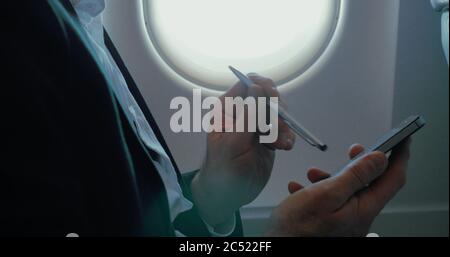 Businessman using smart phone during the flight Stock Photo