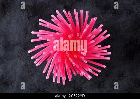 Directly above view of pink plastic drinking straws on black background. Stock Photo