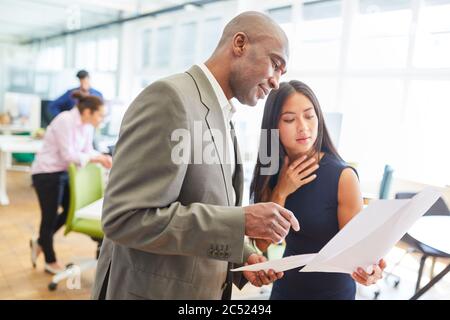 Multicultural business people in the office talk together about business documents Stock Photo