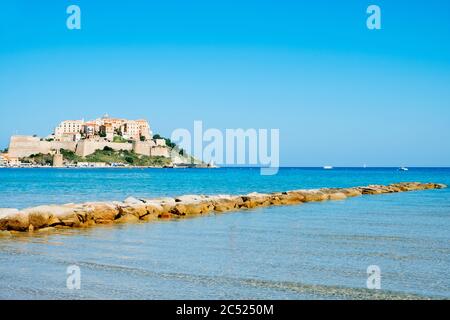 a view of Calvi, in Corsica, France, with its famous citadel on the rigth on the top of a promontory, and the Mediterranean sea in the foreground Stock Photo