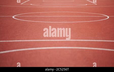 White lines on red empty basketball court on sunny day Stock Photo