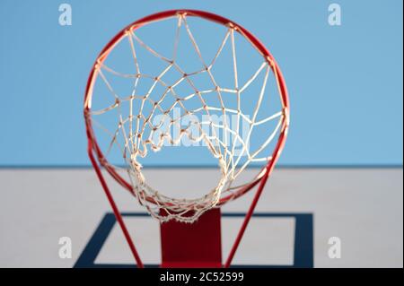 Basketball net on red ring bottom view in blue sky background Stock Photo