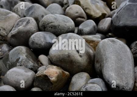 Natural backgrounds and textures of pebbles, stones and rocks on the beach in South Wales. Close up of the different sizes patterns. Stock Photo