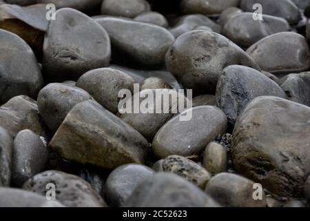 Natural backgrounds and textures of pebbles, stones and rocks on the beach in South Wales. Close up of the different sizes patterns. Stock Photo