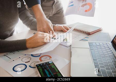 Business team analyzing sales data and economic growth graph chart on office table with laptop and smart phone. Stock Photo