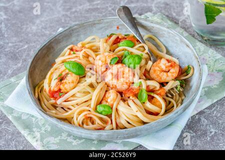 Linguine pasta with prawns in tomato and garlic sauce Stock Photo