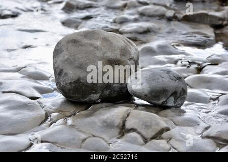 Natural backgrounds and textures of pebbles, stones and rocks on the beach in South Wales. Close up of the different sizes patterns. Stock Photo