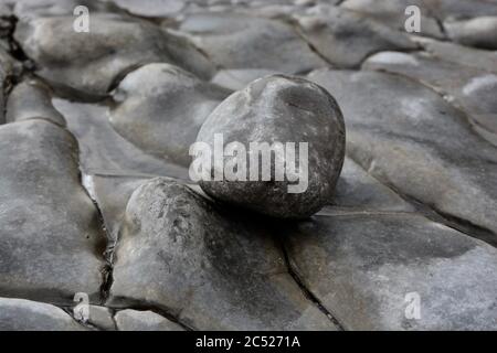 Natural backgrounds and textures of pebbles, stones and rocks on the beach in South Wales. Close up of the different sizes patterns. Stock Photo