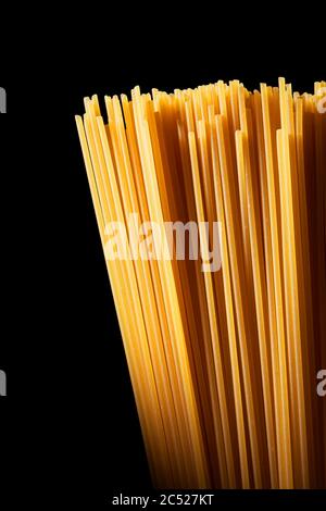 Uncooked raw spaghetti on isolated black background Stock Photo
