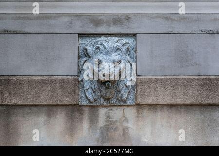 Lion fountain in stone near entrance to a beautiful park. Stone columns in the background. Stock Photo