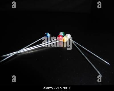 Stack of pins with multi colored heads,on black background. Stock Photo