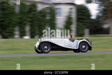 Charles Gordon- Lennox 11th Duke of Richmond driving his 1934 AC 16-80 Six sports car at Goodwood House UK  2002 Stock Photo