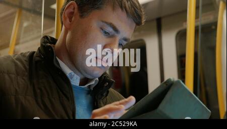 Man Using Tablet PC in Metro Train Stock Photo