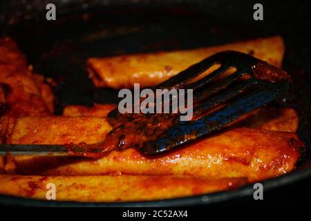 Process of cooking Mexican traditional dish enchiladas with cheese and potatoes Stock Photo