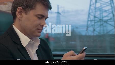 Businessman using smart phone during trip in train Stock Photo