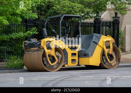 Asphalt Compactor Roller in a residential street. Stock Photo